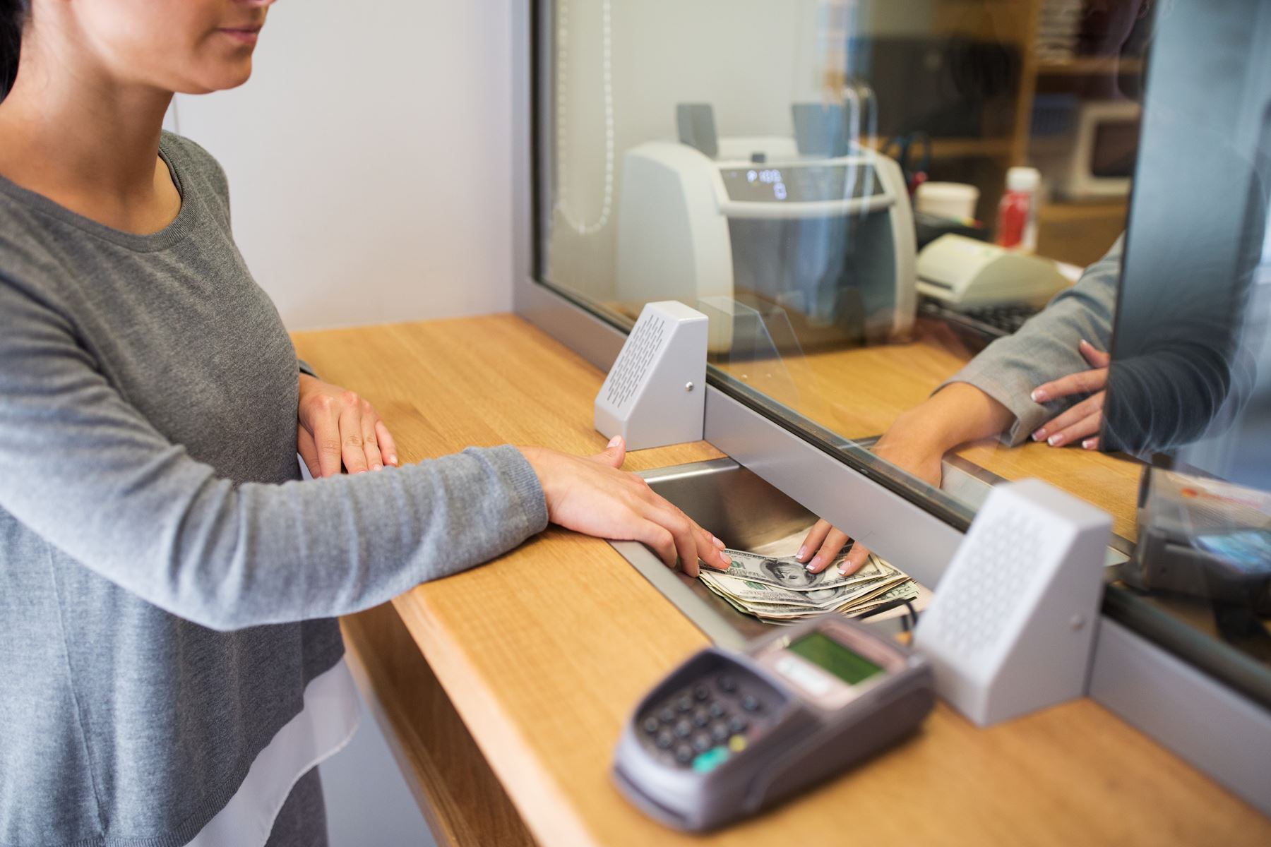 Bank teller handing money to customer