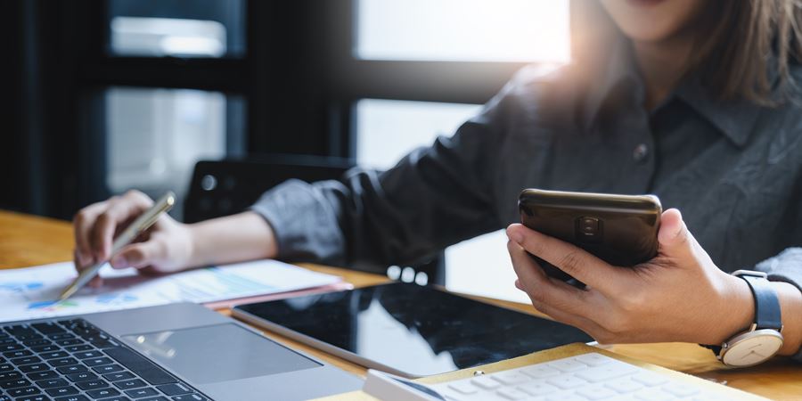 Man holding phone while going over documents