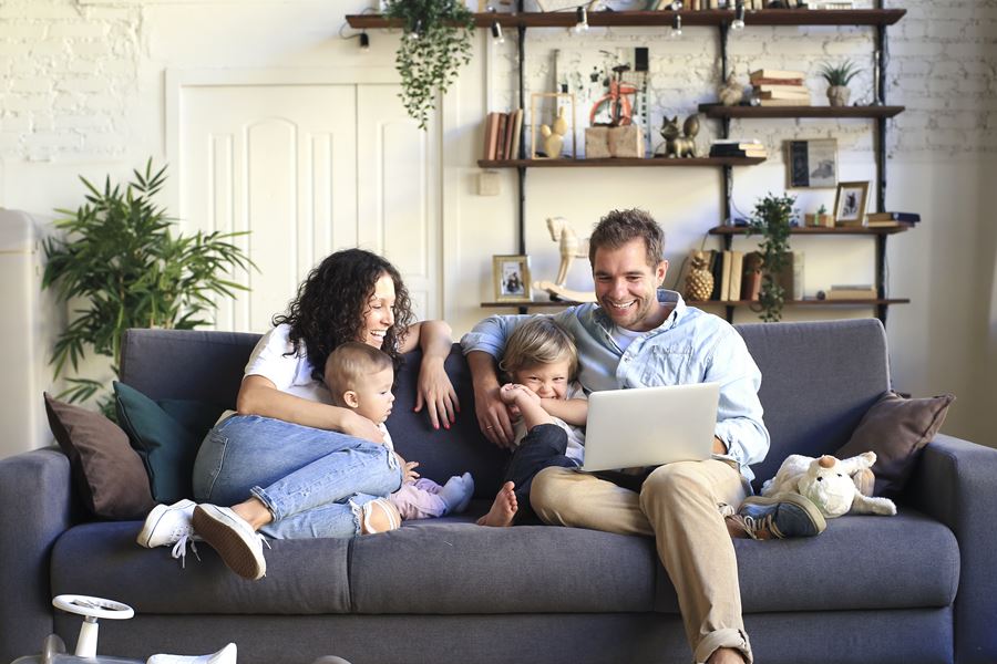 Family sitting on couch watching laptop
