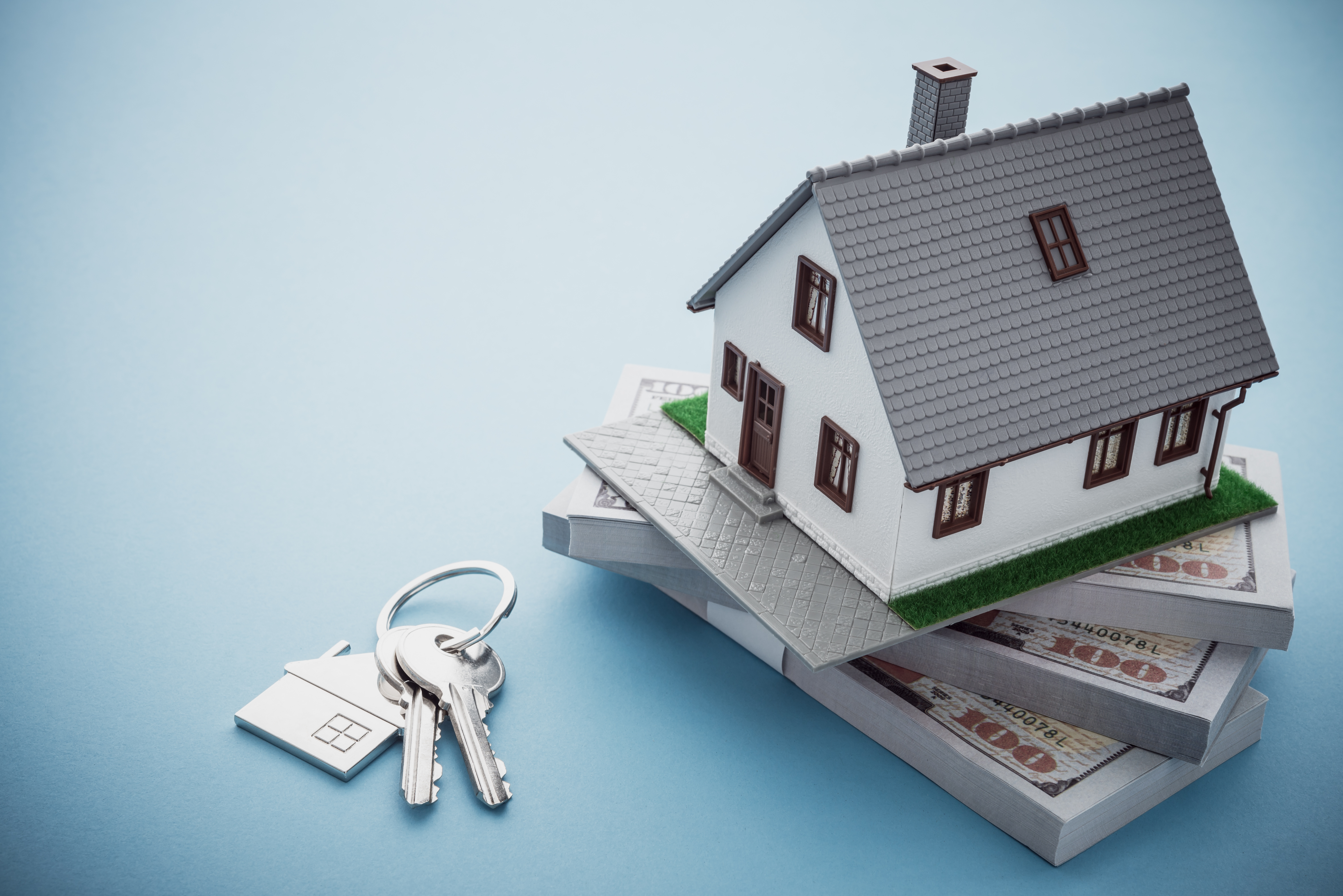 Model house on top of a stack of money